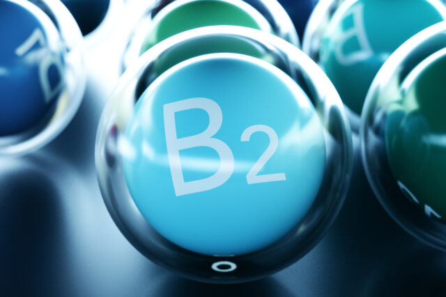 Vitamin B1 Schriftzug auf hellblauem Ball umrandet von einem durchsigtigen Ball auf schwarzem Boden