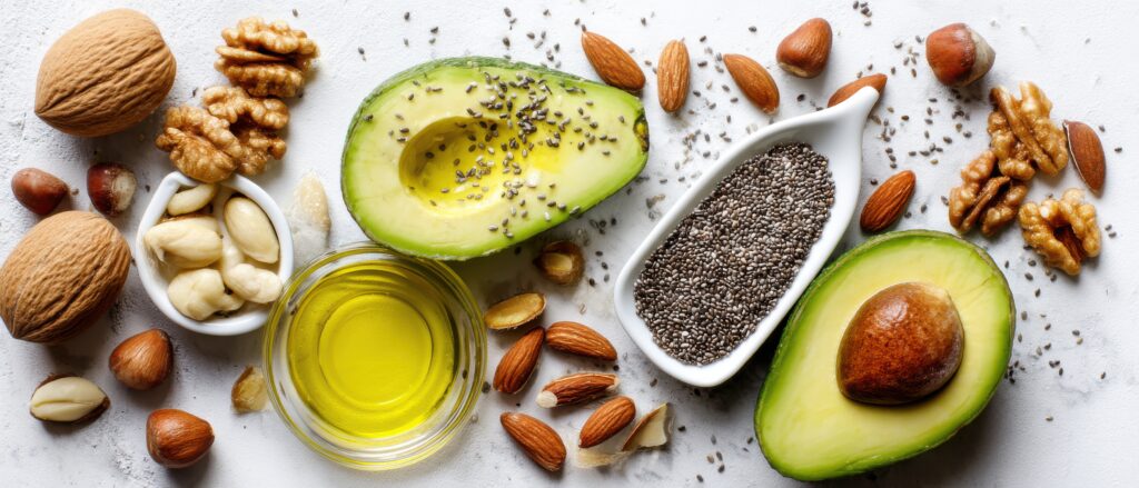 Avocado, Nüsse, Samen und Öl auf weißem Untergrund
