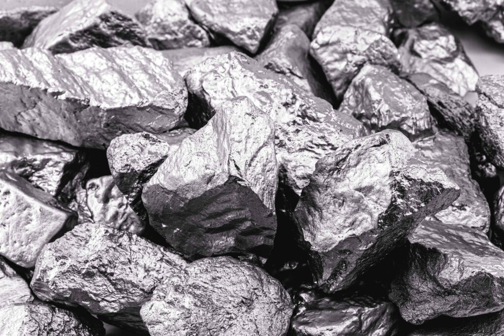 Ein massiver Block aus gräulich-glänzendem Molybdän-Metall in einer industriell-ästhetischen Nahaufnahme.