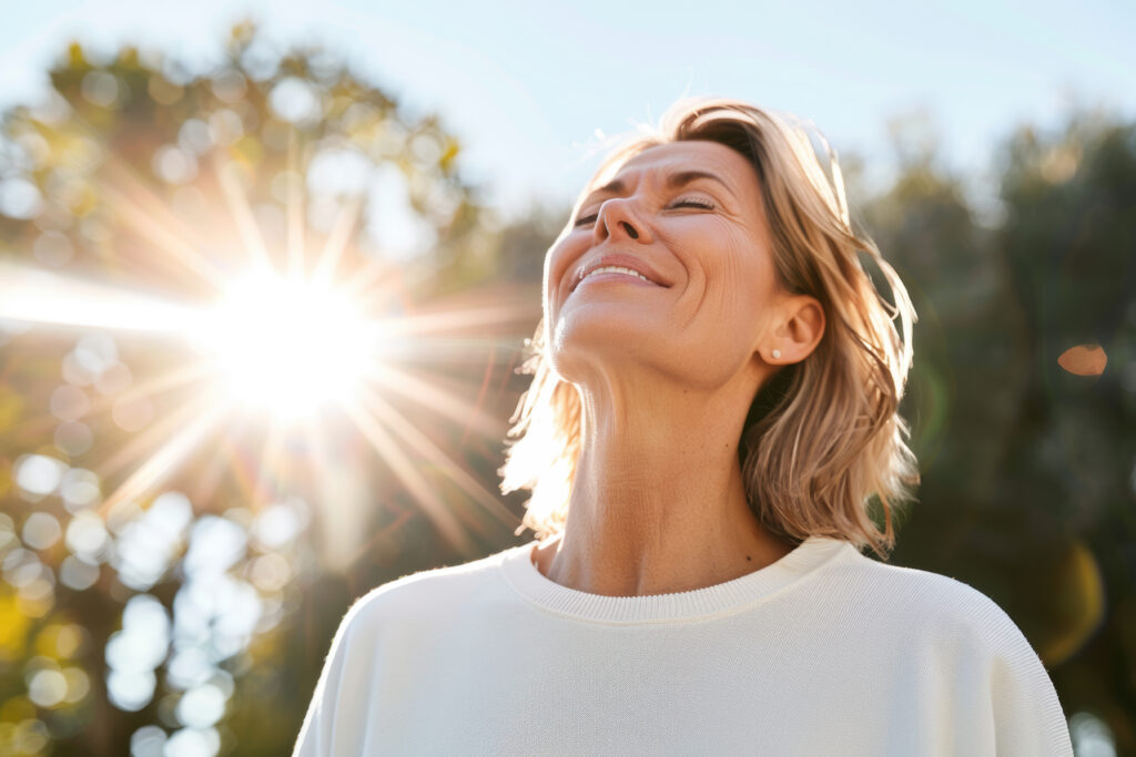 Portrait of happy mature woman enjoying wonderful sunny day in nature.